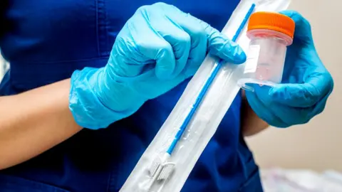 Getty Images Nurse holds cervical screening brush