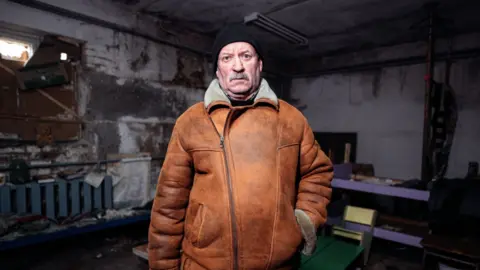 Edward Matthews Man stands in basement