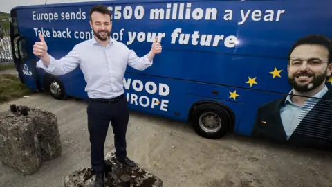 Liam McBurney/PA Colum Eastwood and campaign bus