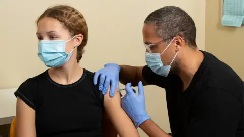 Stock image of a young person receiving a vaccine