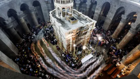 Reuters Christian worshippers attend Mass in the Church of the Holy Sepulchre in Jerusalem (9 April 2023)