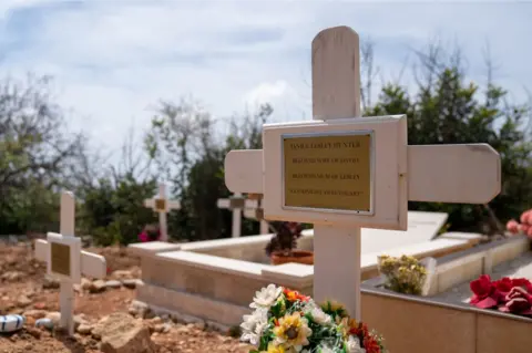 PA Media A cross in a graveyard with Janice's name on it
