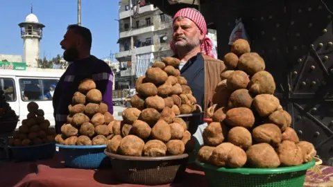 AFP A Syrian man sells desert truffles at a market in the city of Aleppo (28 February 2024)