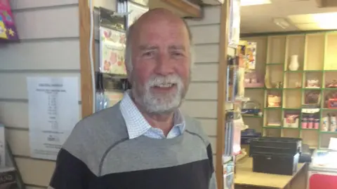 Janet Walters Terry Walters standing in his Post Office