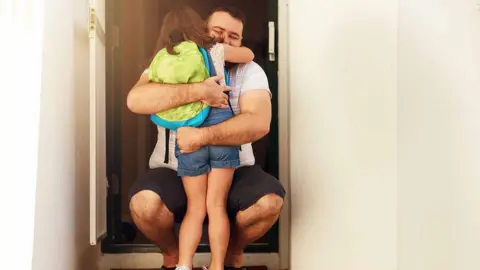 Getty Images Divorced dad hugging kid