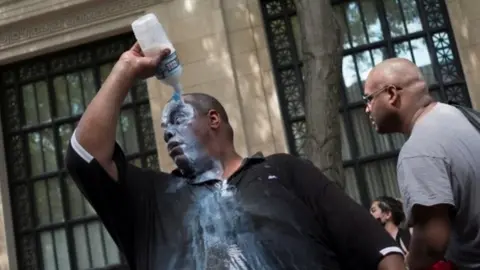 Reuters A man douses himself with a liquid, most likely milk of magnesium, to cope with the effects of pepper spray