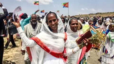 Getty Images Women waving and smiling