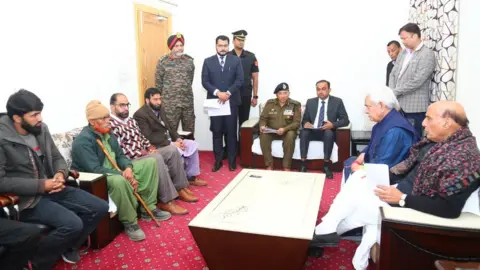 Defence Ministry Defence Minister Rajnath Singh with the families of the three men