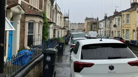 BBC A road in Easton with lots of cars parked on the pavement