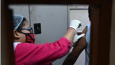 Getty Images A health worker inoculates a man with a dose of Covaxin Covid-19 coronavirus vaccine