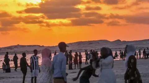 AFP People at sunset on a beach in Mogadishu, Somalia