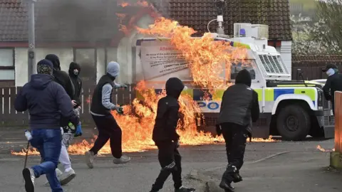 Pacemaker Young hooded men prepare to throw a petrol bomb at police vehicle in Londonderry.