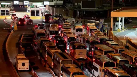 PA Media Coaches wait on Sunday evening to enter the Port of Dover