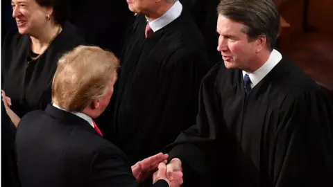 Getty Images US President Donald Trump shakes hands with US Supreme Court Justice Brett Kavanaugh before delivering the State of the Union address