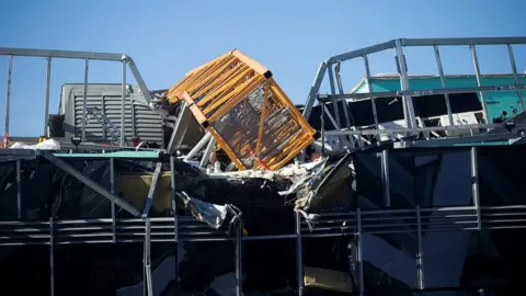 Reuters The fallen crane is seen hanging off a an office building in Seattle, Washington, April 27, 2019