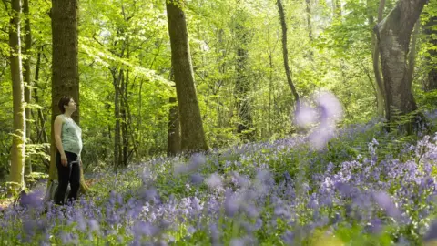 A woman enjoys the bluebell woodland