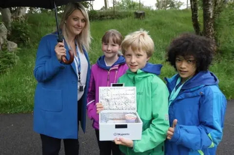 Kevin McGlynn A woman and three children holding an insulated box