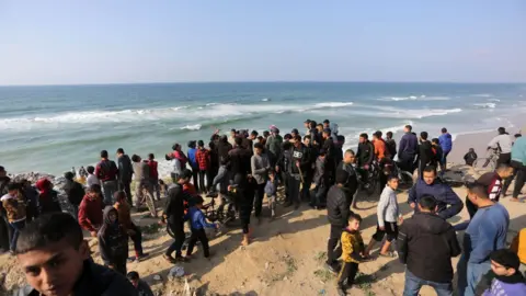 Getty Images Palestinians wait for aids to be airdropped, Deir al balah