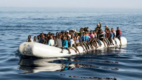 AFP Migrant crisis: Libyan coast guardsmen at sea in an overcrowded dingy with illegal immigrants that were rescued, June 2017