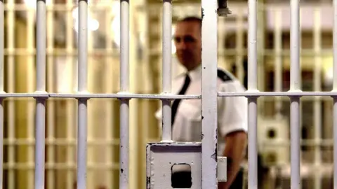 Getty Images Prison officer seen through bars