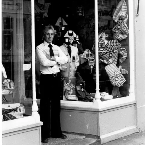 Swann Menswear Old photo of Alan Harvey in doorway