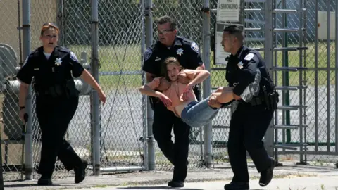 Getty Images A school student being carried by two police officers during an active-shooter drill