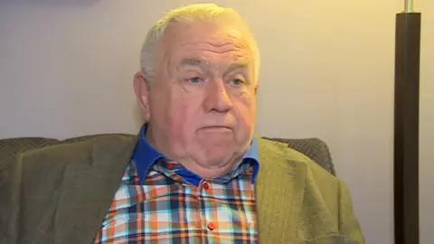 BBC Fergus Wilson wants the video edited to remove the offensive language, or £10,000