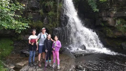 Siobhain Rushworth Sam Rushworth (second left) with Eden, Amelie and Jesse in front of a waterfall at Keld in the Yorkshire Dales