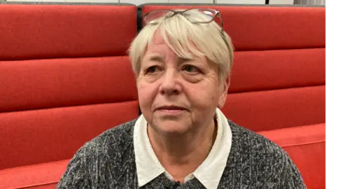 Wendy Buffrey is sitting down and facing slightly away from the camera