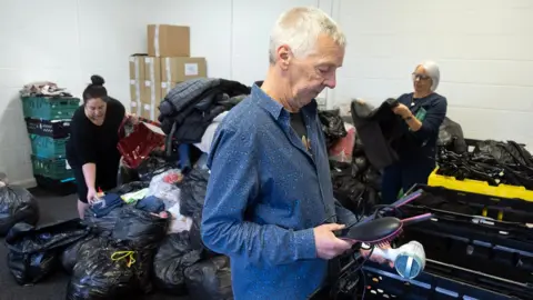 Daniel Holland / LDRS Angela Charlton and Michael Taylor, and operations manager Amy Sturdy, sorting through some of the many donations