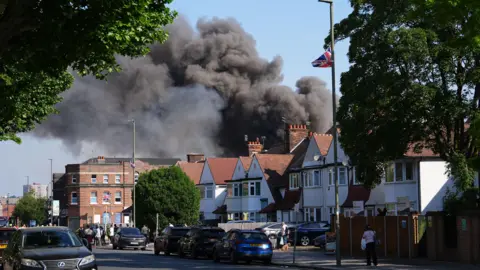 Smoke billows from behind houses 