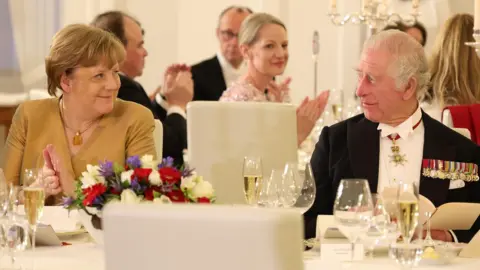 ANDREAS RENTZ/POOL/EPA-EFE/REX/Shutterstock Angela Merkel and King Charles look at each other whilst sat at their table for the state banquet