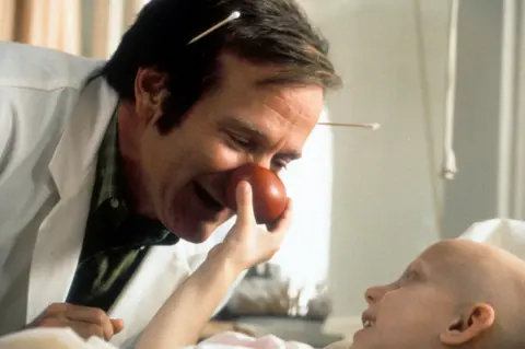 Universal/Getty Images Robin Williams with a child actor in Patch Adams