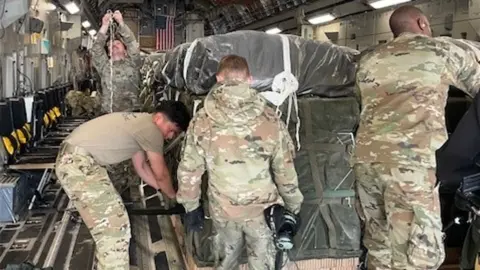 US soldiers preparing aid packages on a plane