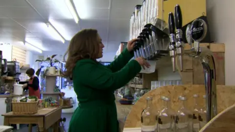 Woman filling a container with food in a refill store