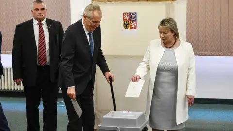 EPA Milos Zeman (C) casts his vote - 26 January