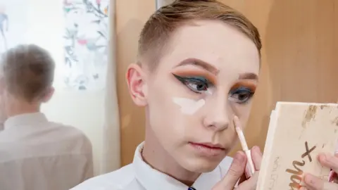 Adam Hughes / SWNS.com Lewis Bailey doing make up