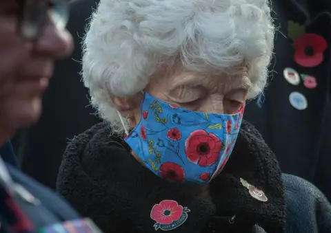 Gilbert Johnston Woman wearing a poppy masked at Billingham's service