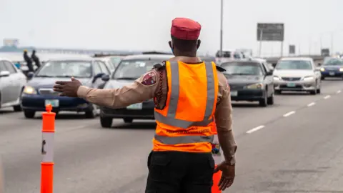 BBC/Ayo Bello Someone directing traffic on the Third Mainland Bridge, Lagos, Nigeria