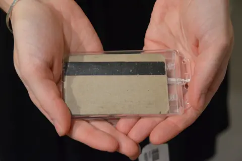 Alamy A woman from Sotheby's auction house holds one of the first two prototype credit cards, made by IBM in the late 1960s