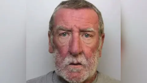 Avon and Somerset Police Mugshot of Simon Steeves. He has grey hair and a grey beard.