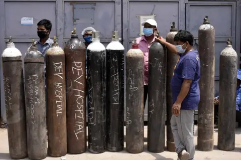 Getty Images Family members of Covid-19 infected people in a queue with empty oxygen cylinders outside a filling centre at Sector 14 on April 29, 2021 in Gurugram, India.