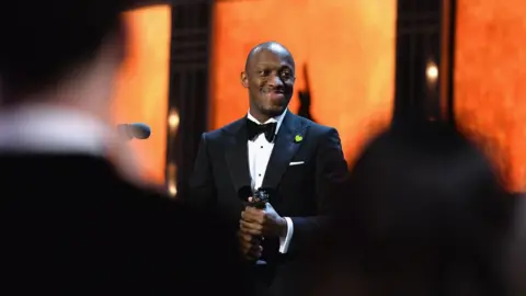 Getty Images Giles Terera receiving his Oliver Award for his performance in Hamilton