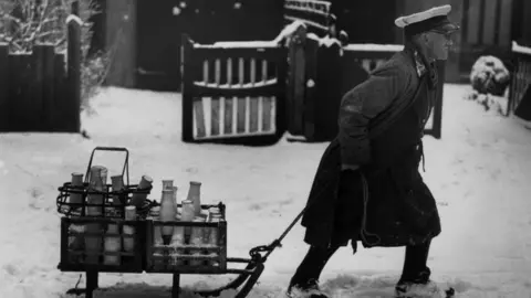 Getty Images 1947: A milkman in Cheam, Surrey, pulling his deliveries through the snow on a sledge