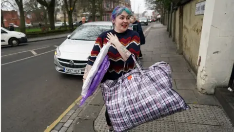 Getty Images A volunteer carries donations through a street in Hartlepool