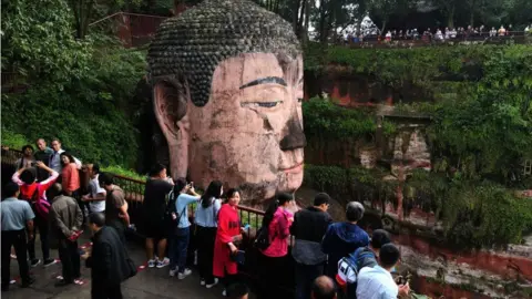 Getty Images Tourists visit the Leshan Buddha in Sichuan province
