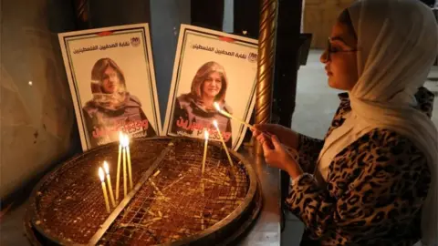 EPA a woman lights a candle in bethlehem