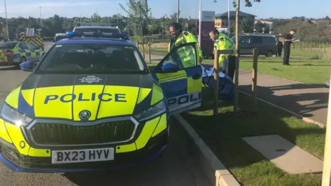 BBC A police car at the scene