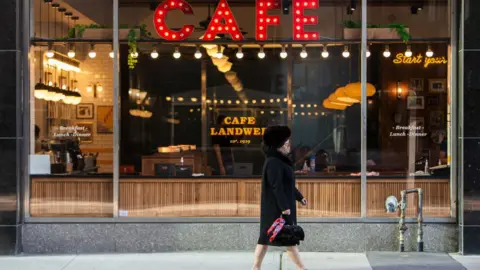 NurPhoto via Getty IMages A woman in a mask walks through downtown Toronto, 7 October, 2020