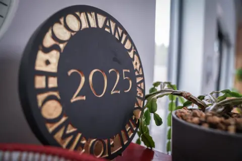 The winners' plaque sits in the kitchen - it is a large circular carving in black, inlaid with gold letters saying "Scotland's Home of the Year 2025".